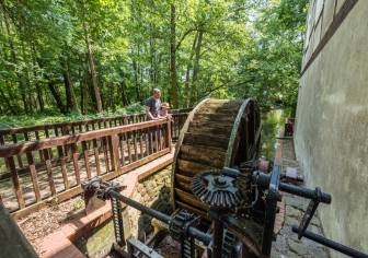 Vorschaubild Vater und Tochter stehen auf einer Brücke nahe eines Waldes und blicken auf das Rad einer alten Seemühle am Untersee in Wusterhausen