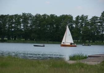 Vorschaubild Boote mit Elektromotor und Segelboote auf dem vom Schilf und Bäumen gesäumten Kyritzer Untersee, um den rundherum der Seerundweg führt